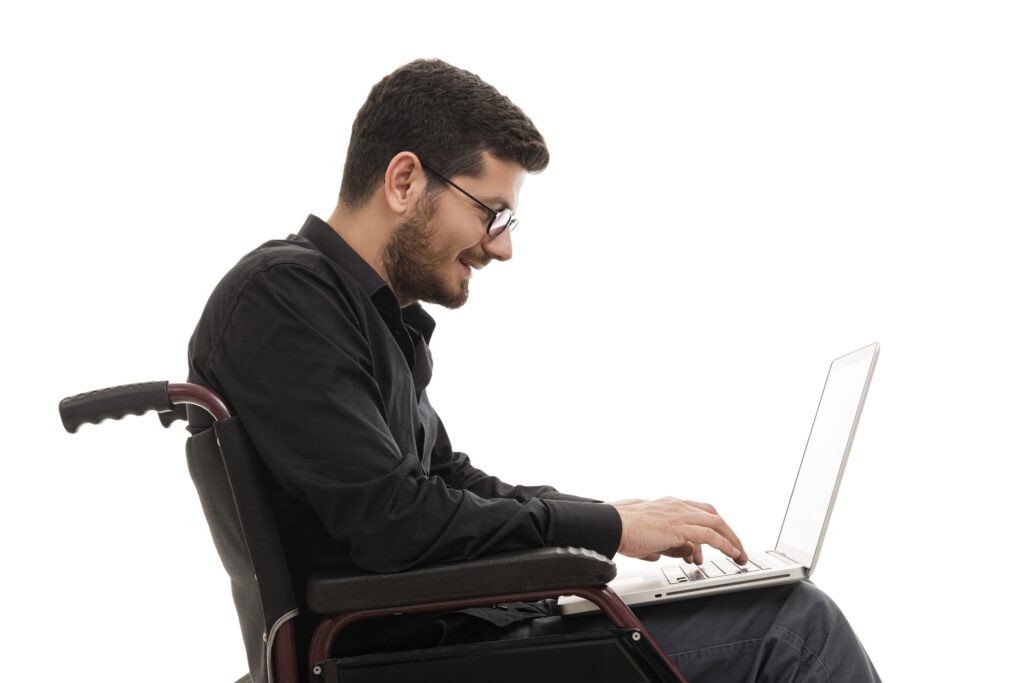 Man sitting in his wheelchair and working on his laptop in a project management environment
